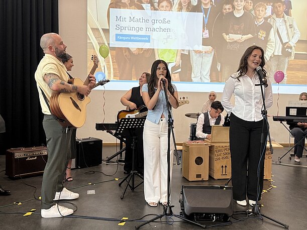 Zwei Sängerinnen mit Gitarrenbegleitung auf der Bühne der Entlassungsfeier
