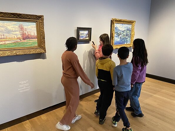 Kinder betrachten Gemälde in goldenen Rahmen im Museum