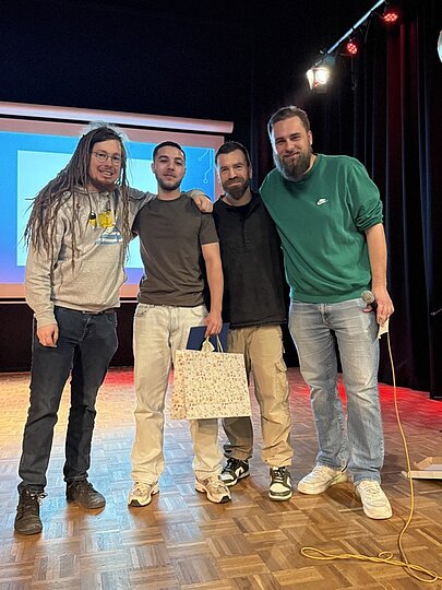 Vier Männer posieren mit Geschenktüte auf der Bühne bei Like a Star
