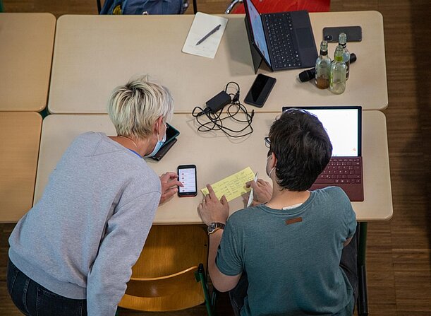 Zwei Lehrkräfte erproben lernlog am Smartphone und Laptop