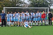 Fußballmannschaft der STSW mit Trainern vor einem Tor auf Kunstrasen