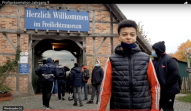 Schüler vor Eingang mit Schild Herzlich Willkommen im Freilichtmuseum