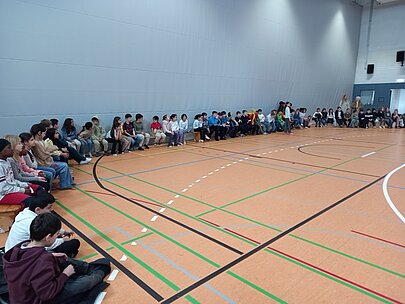 Grundschulkinder sitzen am Rand der Sporthalle bei der Like-a-Star-Feier