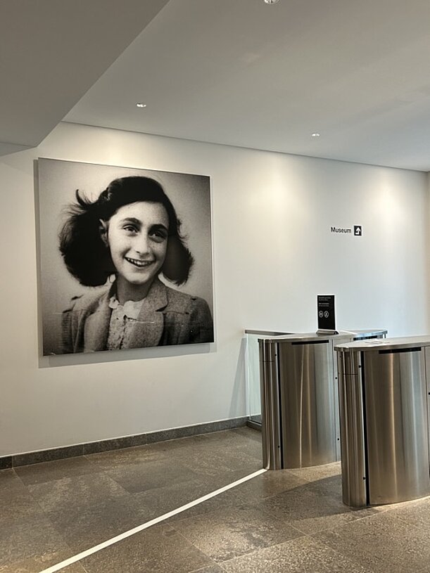 Großes Porträtfoto von Anne Frank im Eingangsbereich des Museums