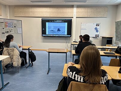 Klassenraum mit Bildschirm, der Buckelwale in der Antarktis zeigt