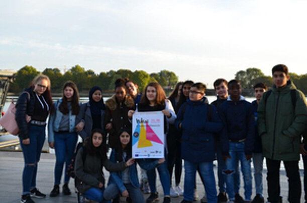 Gruppe von Jugendlichen mit Plakat am Wasser zur Hamburger Klimawoche