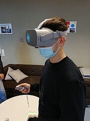 Schüler mit VR-Brille und Controller im Klassenraum