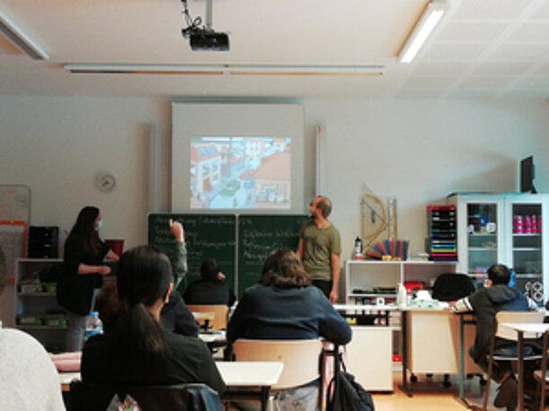 Referent erklärt im Klassenraum mit Beamer Verkehr und Klimawandel