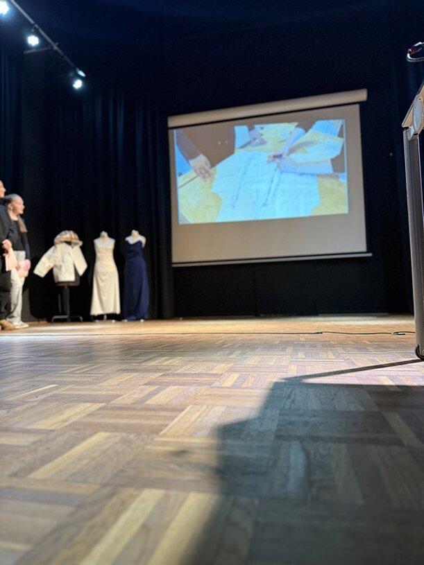Bühne mit Kleiderpuppen und Projektion bei der Profilvorstellung Mode