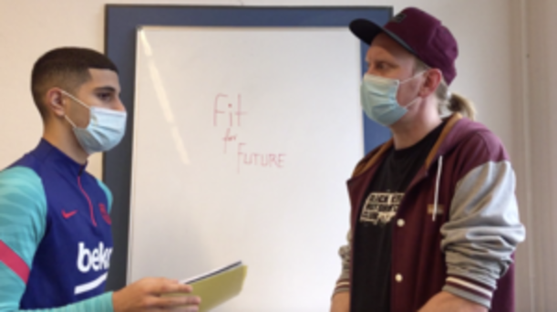 Zwei Schüler vor Whiteboard mit Aufschrift „Fit for Future“