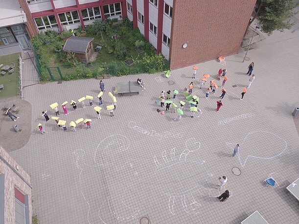 Erstklässler formieren sich auf dem Schulhof zu Meerestieren