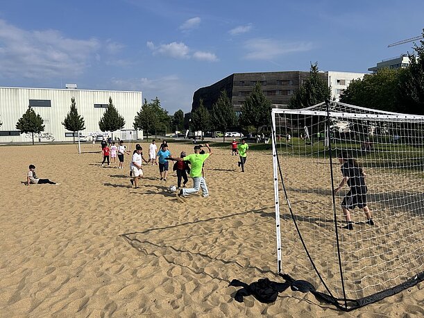 Fußballspiel auf einem Sandplatz mit Tor im Inselpark
