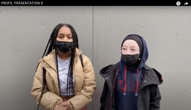 Zwei Schülerinnen mit Masken stellen im Video ihr Profil vor