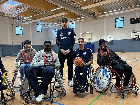Rollstuhlbasketballer der BG Baskets mit Schülern in Sportrollstühlen