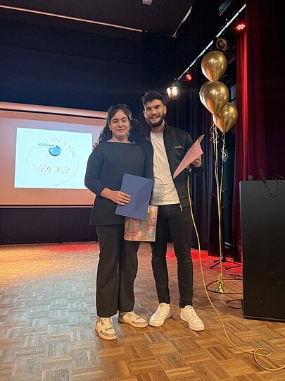 Lehrkraft und Schülerin mit Urkunde auf der Aulabühne bei Like a Star