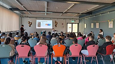 Schülerinnen und Schüler im Saal vor Leinwand bei der Like-a-Star-Ehrung