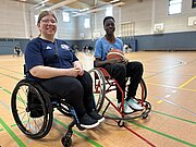 Lara von den BG Baskets und Muhamet im Rollstuhl in der Sporthalle