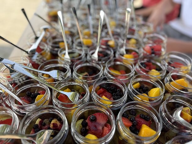 Viele Gläser mit Obstsalat und Löffeln als Stärkung