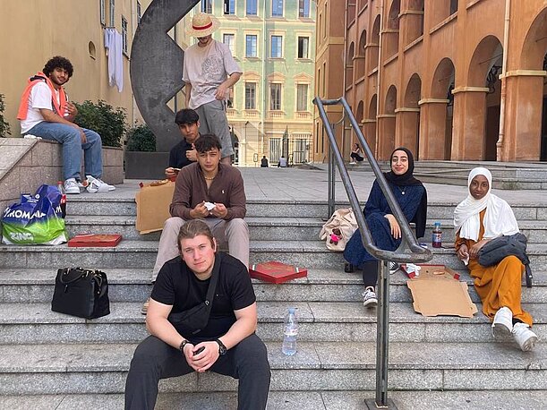 Jugendliche entspannen auf Treppenstufen in der Altstadt von Nizza