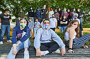 Klasse 10e mit bunten Stoffmasken posiert im Freien unter Bäumen
