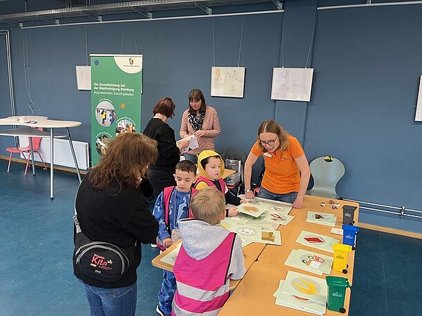 Kinder und Erwachsene an einem Experimentiertisch im MZE