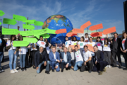 Schülergruppe mit bunten Schildern vor großem Globus zur Hamburger Klimawoche