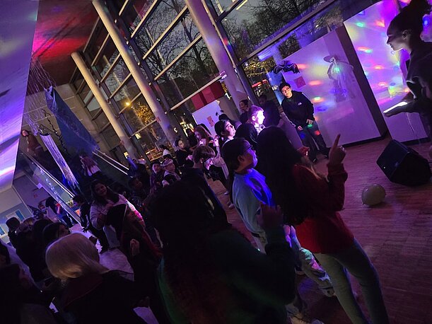 Volle Tanzfläche mit Lichteffekten bei der Halloween-Party der 5. und 6. Klassen