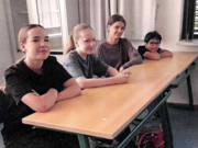 Vier Schülerinnen und Schüler sitzen beim Schweizer Austausch an einem Tisch