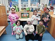 Sechs Kinder mit selbst gebastelten Figuren im Klassenraum nach dem Vorlesewettbewerb
