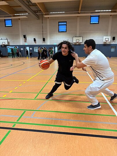 Zwei Schüler im Basketball-Zweikampf in der Sporthalle am Perlstieg